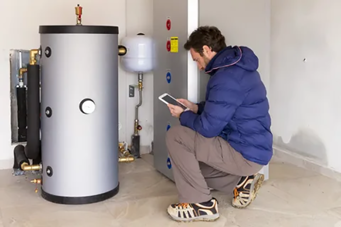 A technician installing an energy-efficient tank water heater, showcasing modern technology designed to reduce energy consumption and lower utility bills for homeowners and businesses